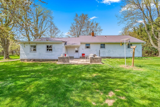 8531 S Waldron Rd, Pittsford, MI 49271 - rear view of house with a patio, a yard, a chimney, and metal roof