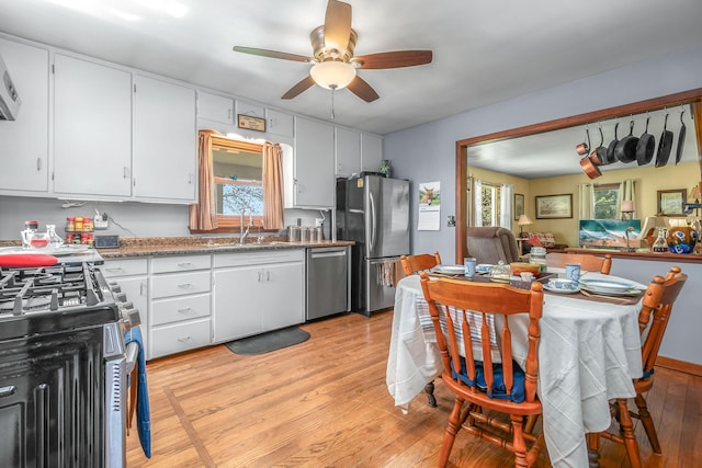 8531 S Waldron Rd, Pittsford, MI 49271 - kitchen with white cabinets, appliances with stainless steel finishes, a sink, light wood finished floors, and a ceiling fan