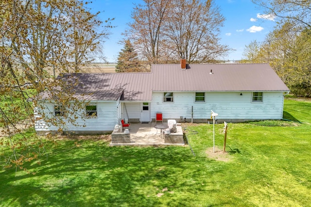 8531 S Waldron Rd, Pittsford, MI 49271 - rear view of property featuring a patio, a lawn, a chimney, and metal roof