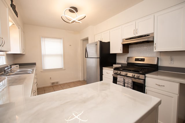 kitchen with visible vents, white cabinetry, under cabinet range hood, a sink, and appliances with stainless steel finishes