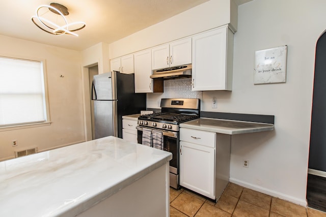 kitchen featuring visible vents, light tile patterned flooring, under cabinet range hood, white cabinets, and appliances with stainless steel finishes