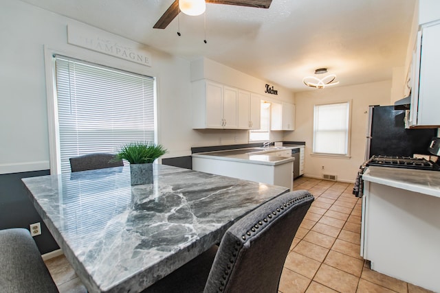 kitchen with white cabinets, ceiling fan, appliances with stainless steel finishes, light tile patterned floors, and visible vents