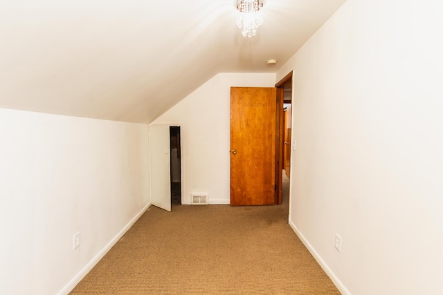additional living space with visible vents, vaulted ceiling, baseboards, a chandelier, and carpet
