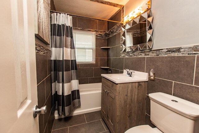 full bathroom featuring tile patterned flooring, vanity, toilet, tile walls, and shower / tub combo