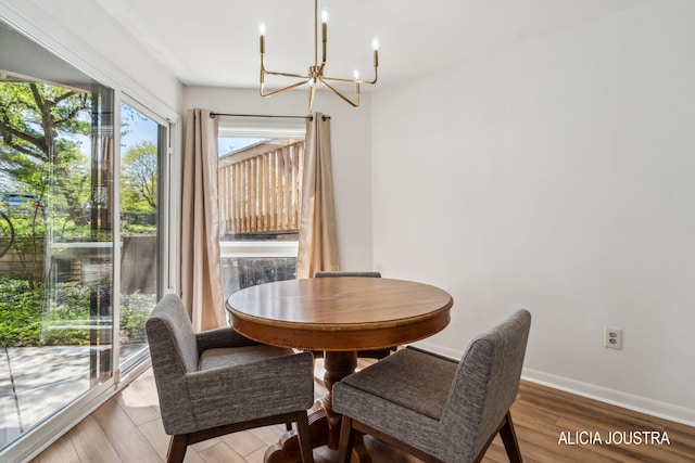 dining area with an inviting chandelier, baseboards, and wood finished floors