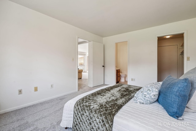 carpeted bedroom featuring connected bathroom and baseboards