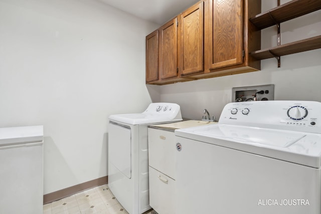 laundry area with baseboards, light floors, cabinet space, and washer and clothes dryer