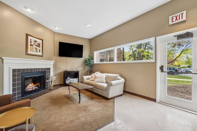 living area with a tiled fireplace, baseboards, and recessed lighting