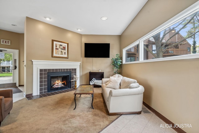 living room with baseboards, recessed lighting, a tile fireplace, and visible vents