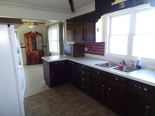 kitchen with ceiling fan, black microwave, a sink, freestanding refrigerator, and a peninsula