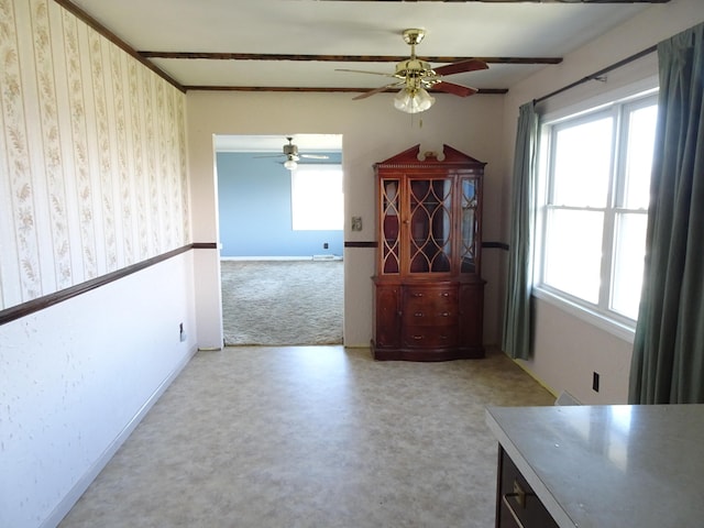 interior space with carpet floors, a ceiling fan, and baseboards