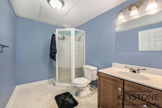 bathroom featuring baseboards, vanity, toilet, and a shower stall