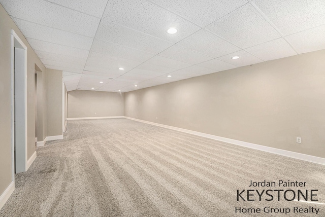 finished basement with baseboards, carpet flooring, recessed lighting, and a paneled ceiling