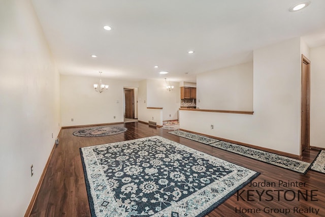 interior space with baseboards, recessed lighting, a notable chandelier, and dark wood-style floors