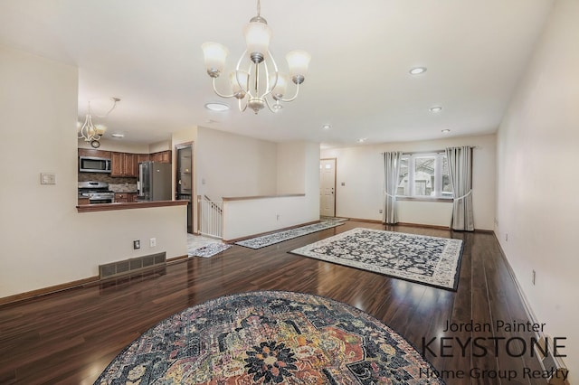 interior space featuring an inviting chandelier, recessed lighting, baseboards, wood finished floors, and visible vents