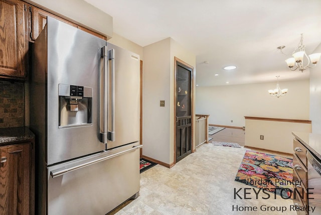 kitchen featuring an inviting chandelier, decorative backsplash, baseboards, stainless steel refrigerator with ice dispenser, and recessed lighting