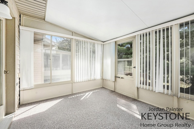 unfurnished sunroom featuring plenty of natural light, carpet floors, and vaulted ceiling