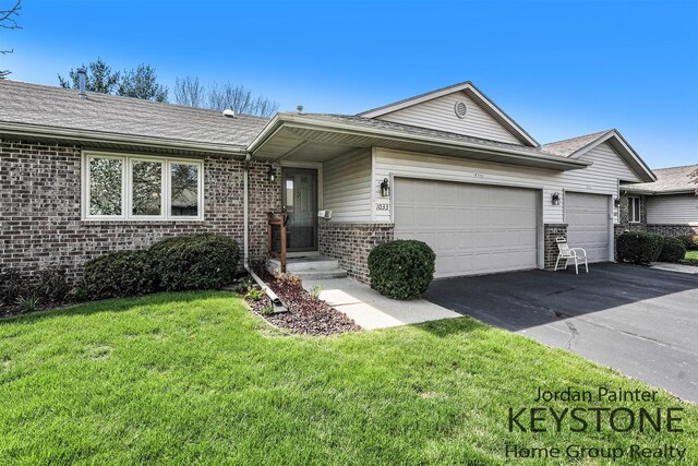 ranch-style house featuring brick siding, driveway, a front yard, and a garage