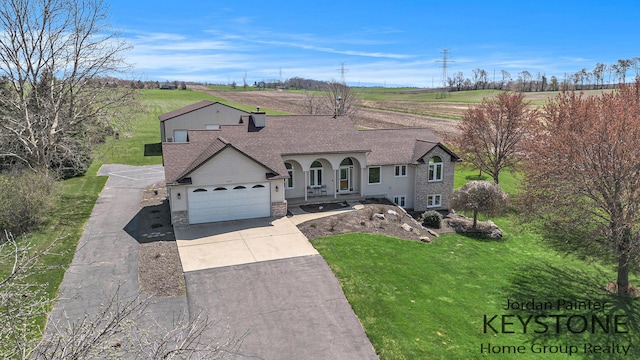 view of front facade featuring stone siding, a front yard, a shingled roof, concrete driveway, and an attached garage