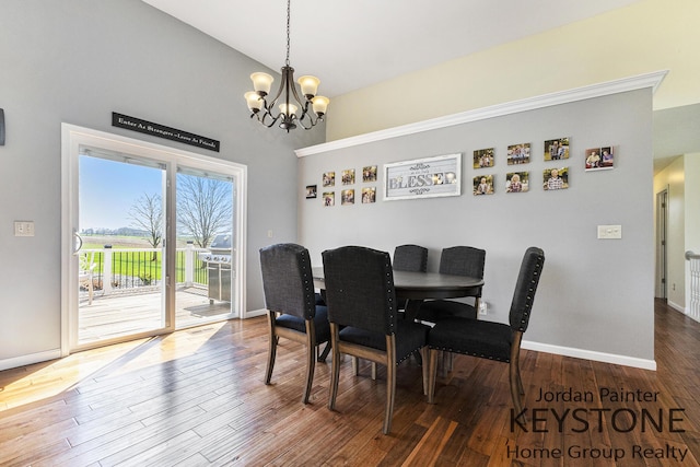 dining room with baseboards, high vaulted ceiling, wood finished floors, and a notable chandelier