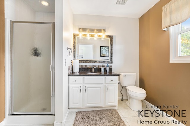 bathroom with vanity, toilet, baseboards, tile patterned floors, and a shower stall
