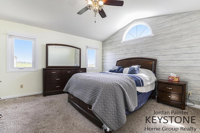 bedroom featuring wooden walls, carpet flooring, ceiling fan, baseboards, and lofted ceiling