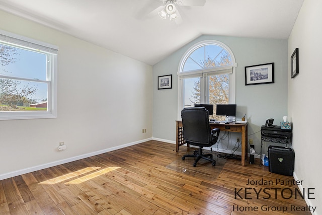 home office with plenty of natural light, a ceiling fan, vaulted ceiling, and hardwood / wood-style floors