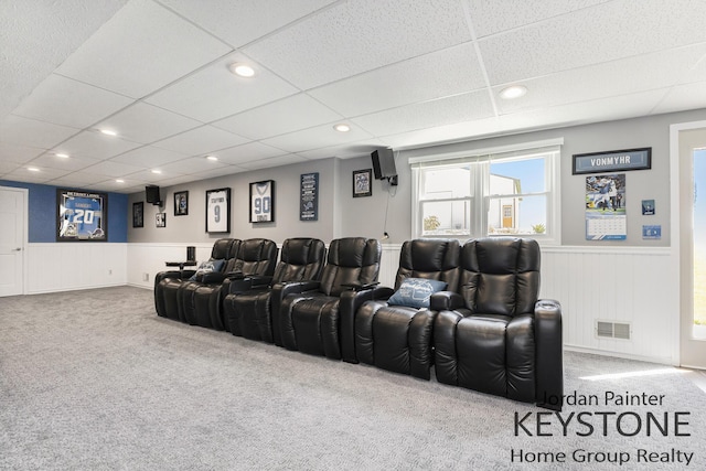 cinema room with visible vents, a wainscoted wall, carpet, a drop ceiling, and recessed lighting