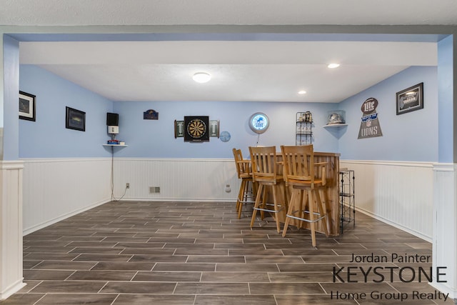 bar featuring wood tiled floor, visible vents, a dry bar, wainscoting, and recessed lighting