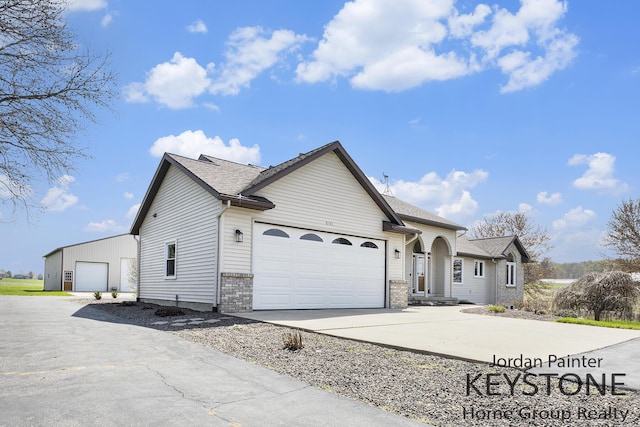 view of front of house featuring brick siding, an attached garage, and driveway