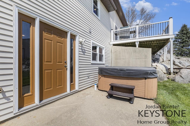 view of patio / terrace featuring a hot tub and a deck