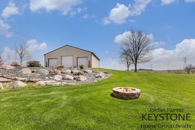 view of yard with an outdoor fire pit, an outbuilding, and a detached garage