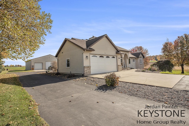 exterior space featuring an outbuilding, an attached garage, and concrete driveway