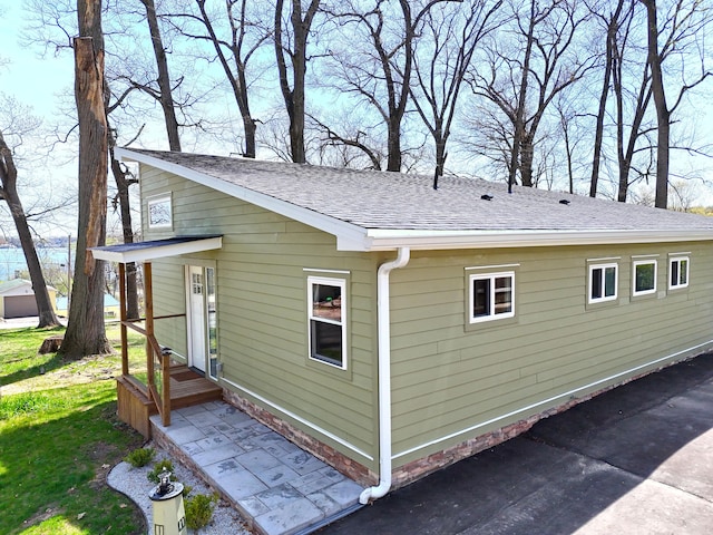 view of property exterior with roof with shingles