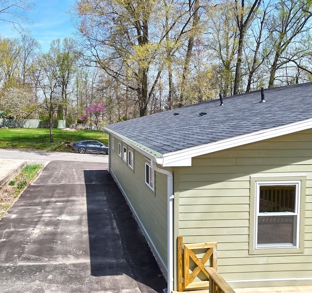 view of property exterior with a shingled roof