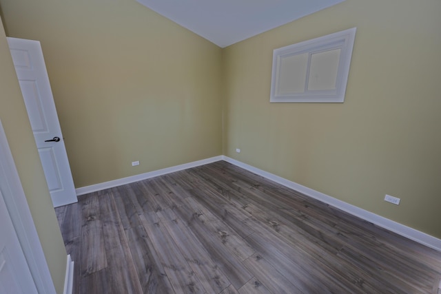 spare room featuring baseboards and dark wood-style floors