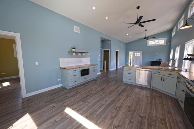 kitchen featuring a ceiling fan, stainless steel dishwasher, a sink, high vaulted ceiling, and wood counters