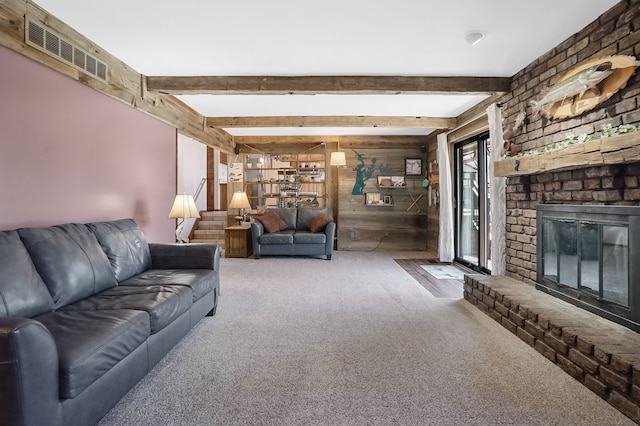 living area with beamed ceiling, carpet floors, a fireplace, and wood walls