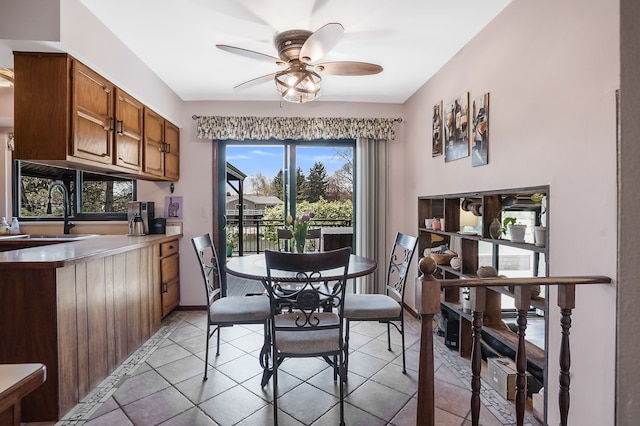 dining room with baseboards, a ceiling fan, and light tile patterned flooring
