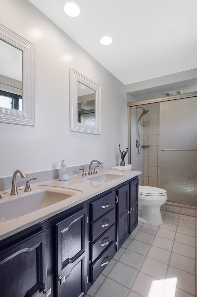 bathroom with tile patterned flooring, a sink, a stall shower, and toilet