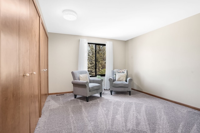 sitting room featuring carpet floors and baseboards