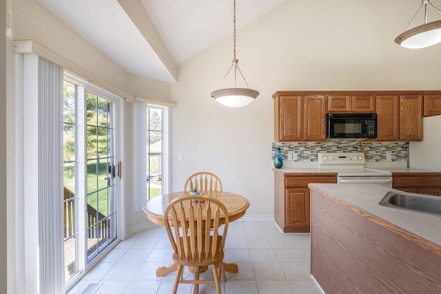 kitchen featuring brown cabinets, black microwave, white range with electric cooktop, backsplash, and vaulted ceiling