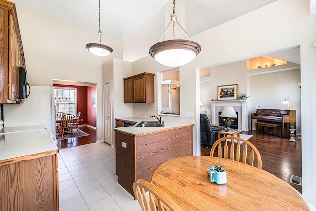 dining area with a lit fireplace, visible vents, light tile patterned floors, baseboards, and a chandelier
