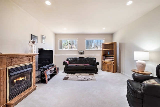 carpeted living room with recessed lighting, baseboards, and a glass covered fireplace