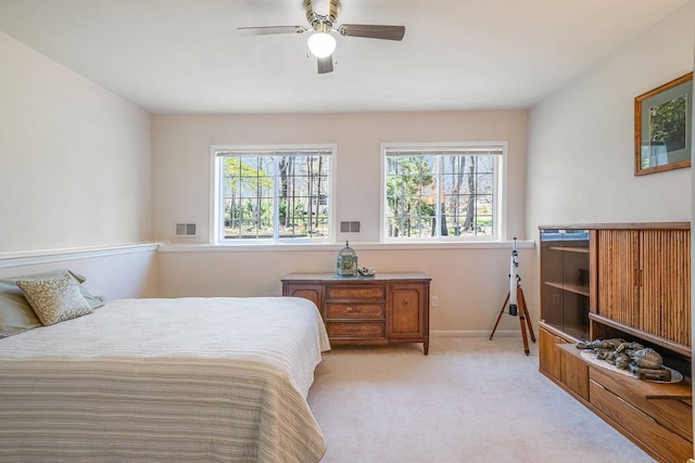 bedroom featuring light colored carpet, ceiling fan, visible vents, and baseboards