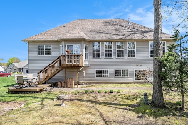back of house with a yard, stairway, a wooden deck, and roof with shingles