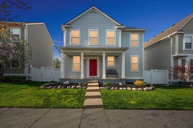 traditional home with a gate, fence, covered porch, and a front yard