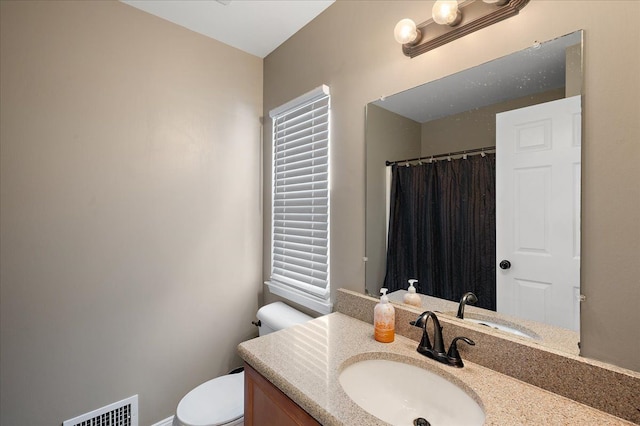 bathroom featuring vanity, visible vents, toilet, and a shower with curtain