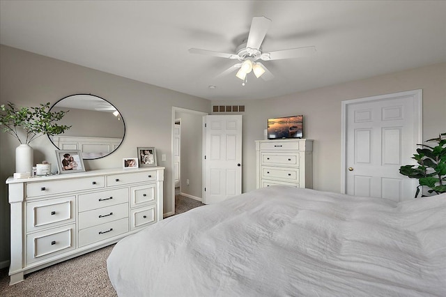 carpeted bedroom with a ceiling fan, baseboards, and visible vents