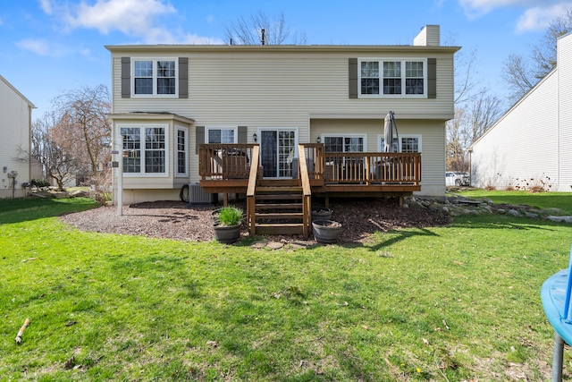 back of property with a yard, a chimney, central AC unit, and a wooden deck